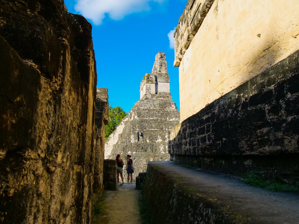 a group of people walking down a narrow street