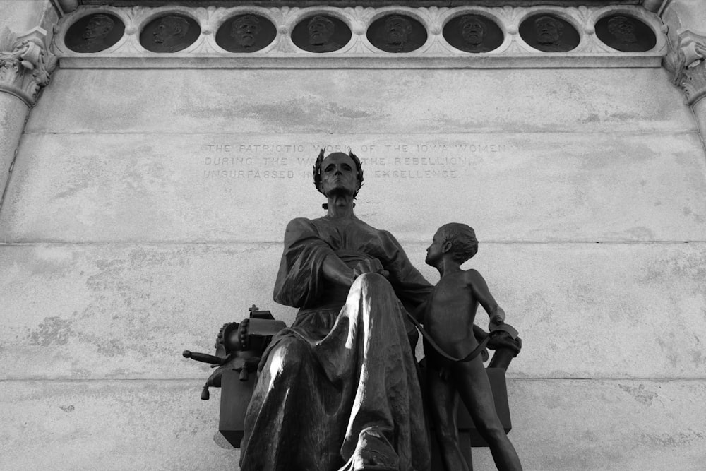 uma foto em preto e branco de uma estátua de uma mãe e uma criança
