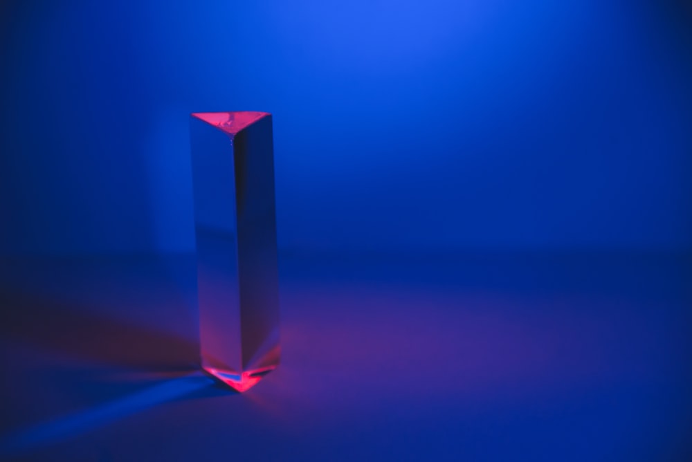 a tall glass object sitting on top of a blue floor