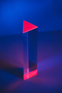 A sleek prism with light entering from the right, dispersing into three vibrant rays of deep abyss, arctic teal, and glacier blue against an ice white background.