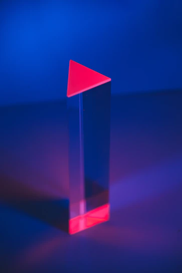 A sleek prism with light entering from the right, dispersing into three vibrant rays of deep abyss, arctic teal, and glacier blue against an ice white background.