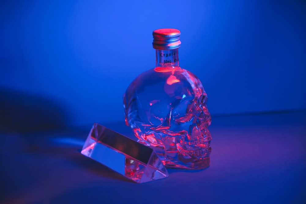 a glass bottle with a red light on top of it