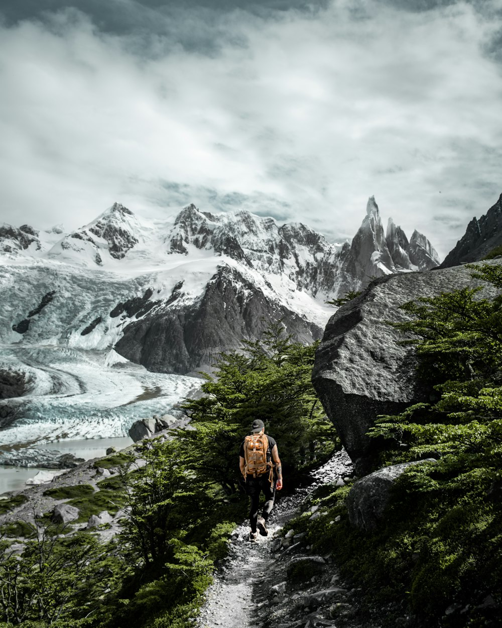 a man hiking up a trail in the mountains