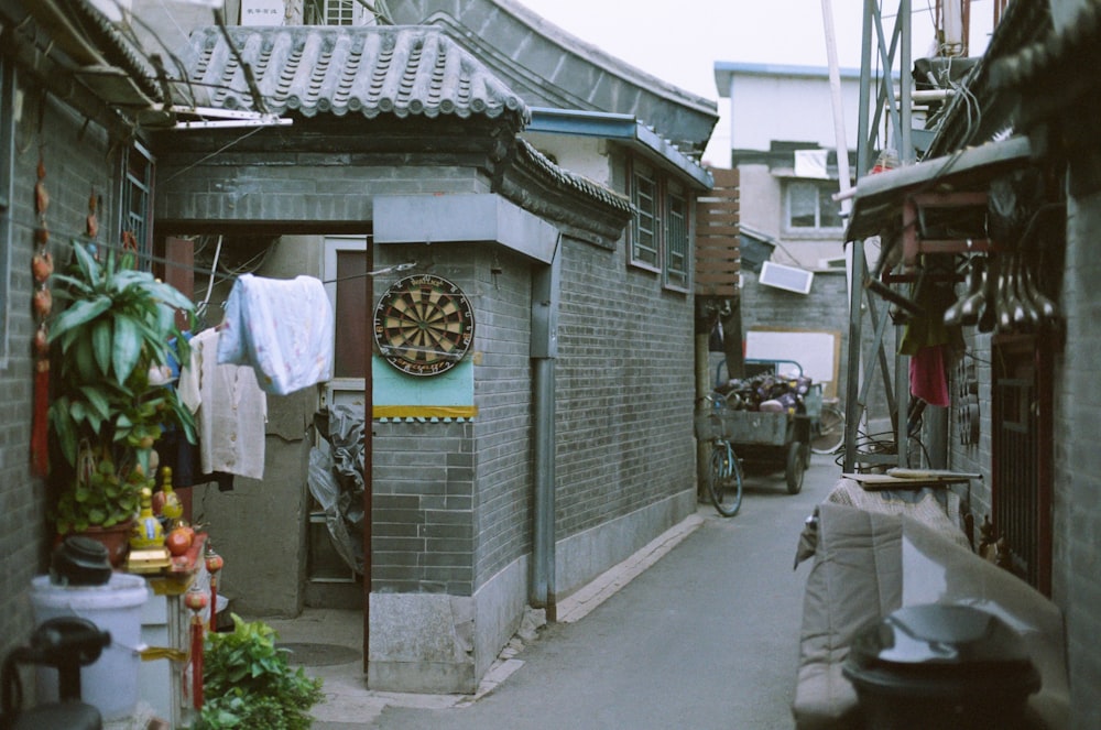 a narrow alley with a clock on the wall