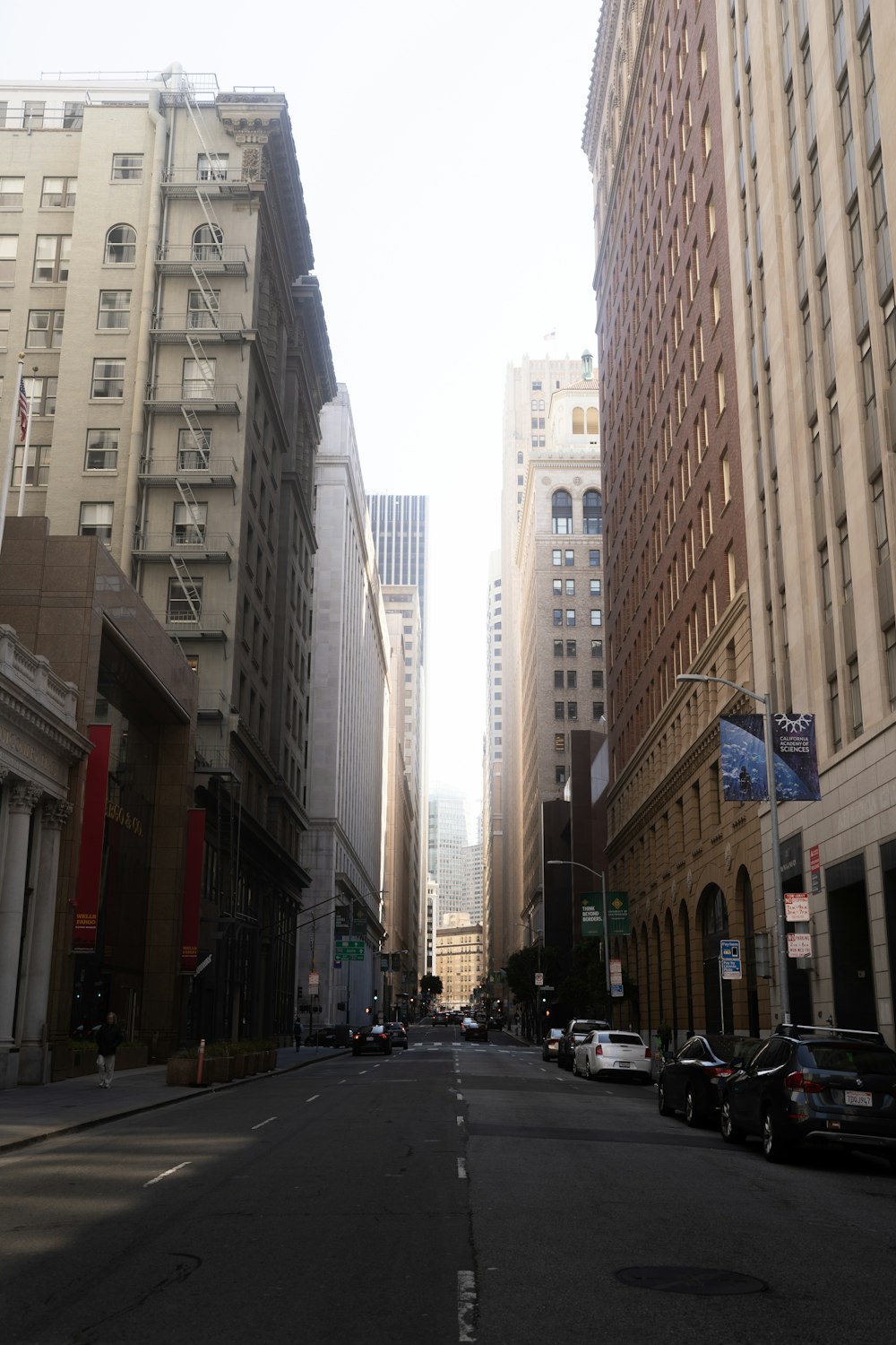 a city street lined with tall buildings and parked cars