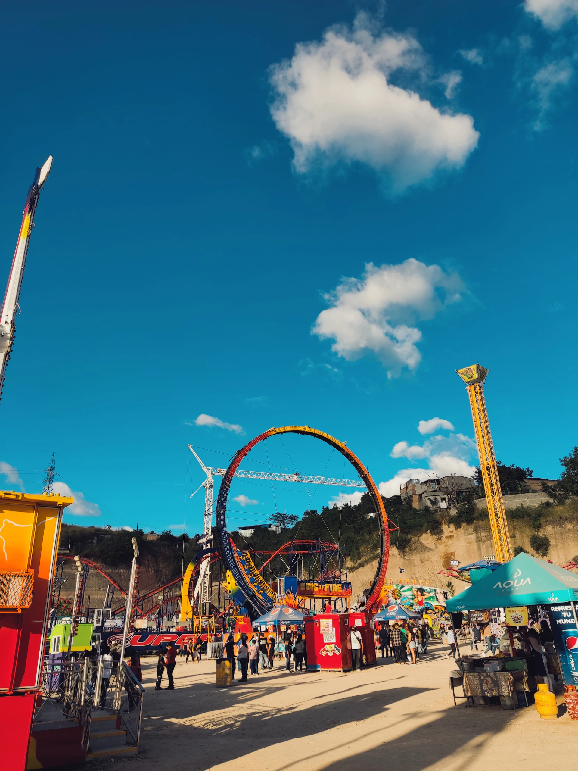 Happy families enjoying the vibrant atmosphere of Hacienda Nápoles theme park, with colorful rides and smiling faces.