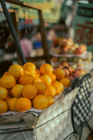 Bright orange oranges ready for eating or juicing on a market stall.