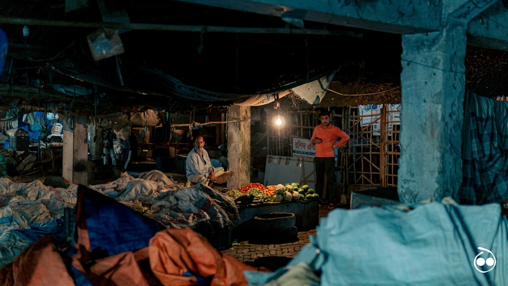 a man standing in a room filled with lots of clothes