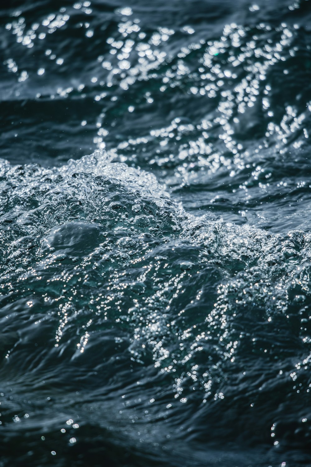 a close up of the water with a bird in the foreground