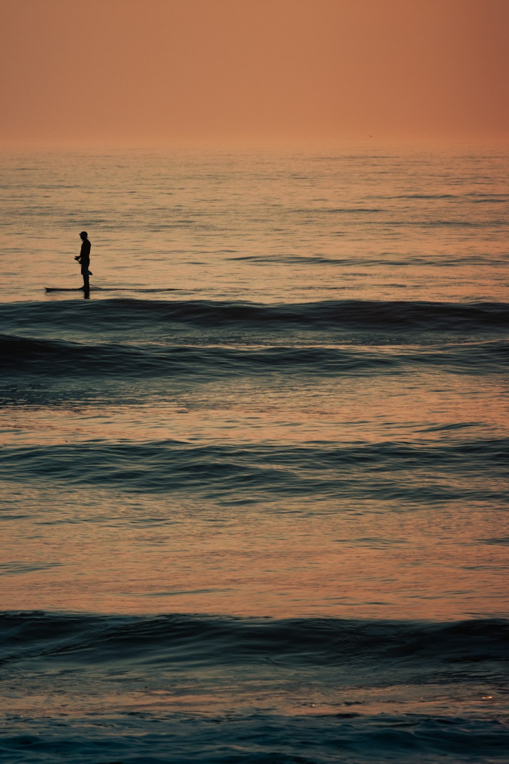 a person standing on a surfboard in the ocean