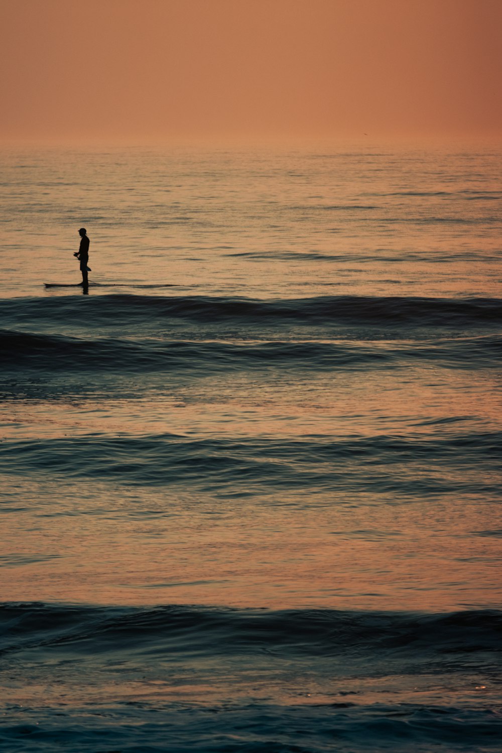 Una persona in piedi su una tavola da surf nell'oceano