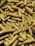 A large quantity of dried yellow corn cobs piled together, with visible kernels arranged in rows. The corn cobs vary in size and are stacked on a surface, possibly for storage or drying out.