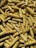 A large quantity of dried yellow corn cobs piled together, with visible kernels arranged in rows. The corn cobs vary in size and are stacked on a surface, possibly for storage or drying out.