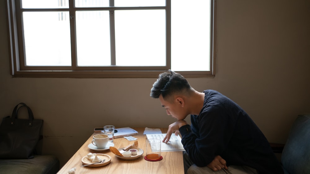 a man sitting at a table with a cup of coffee