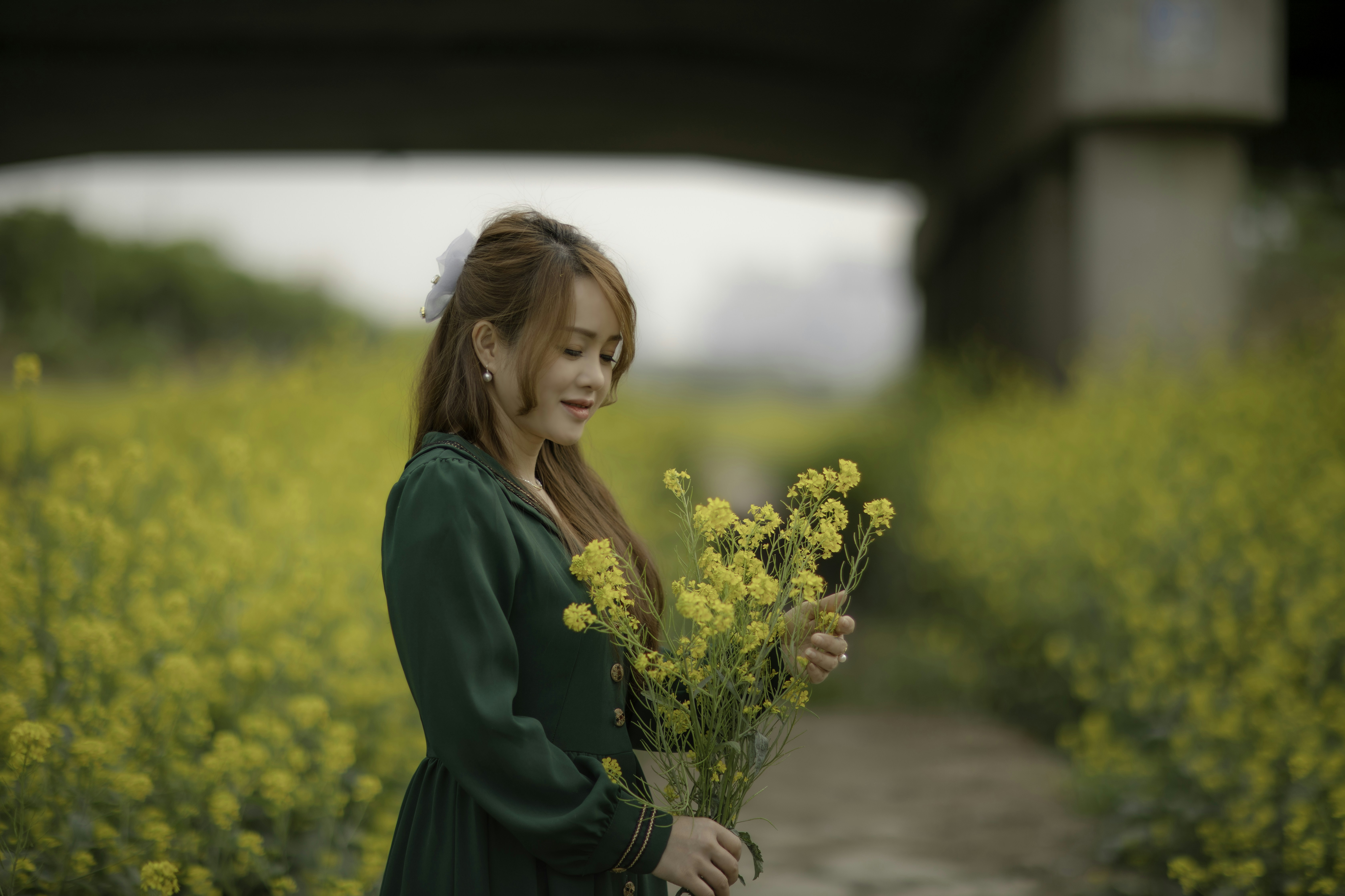 a woman in a green dress holding a bunch of flowers