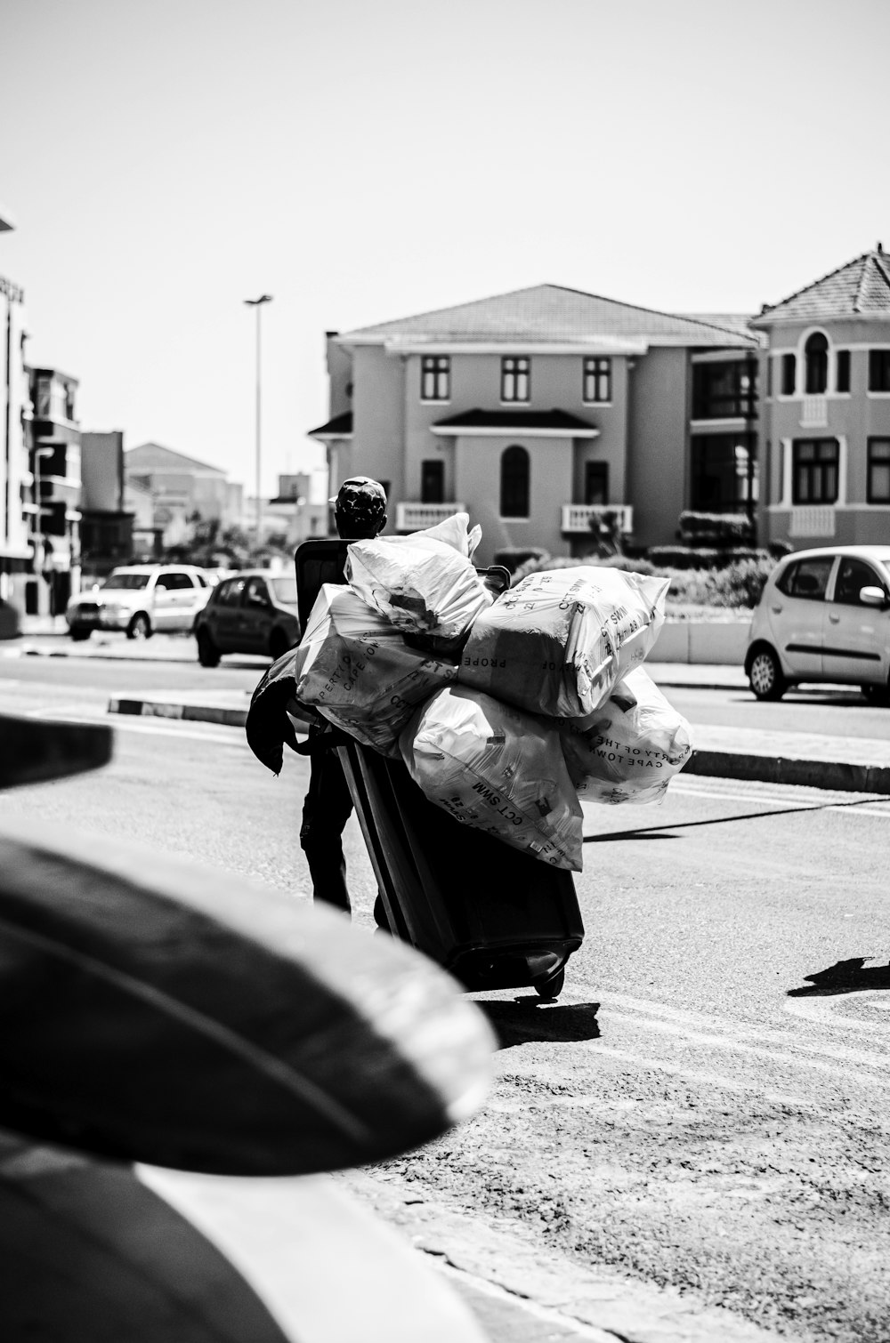 a black and white photo of a person carrying bags