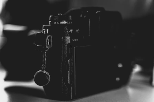 Close-up of a professional camera capturing a live event in a dark venue.