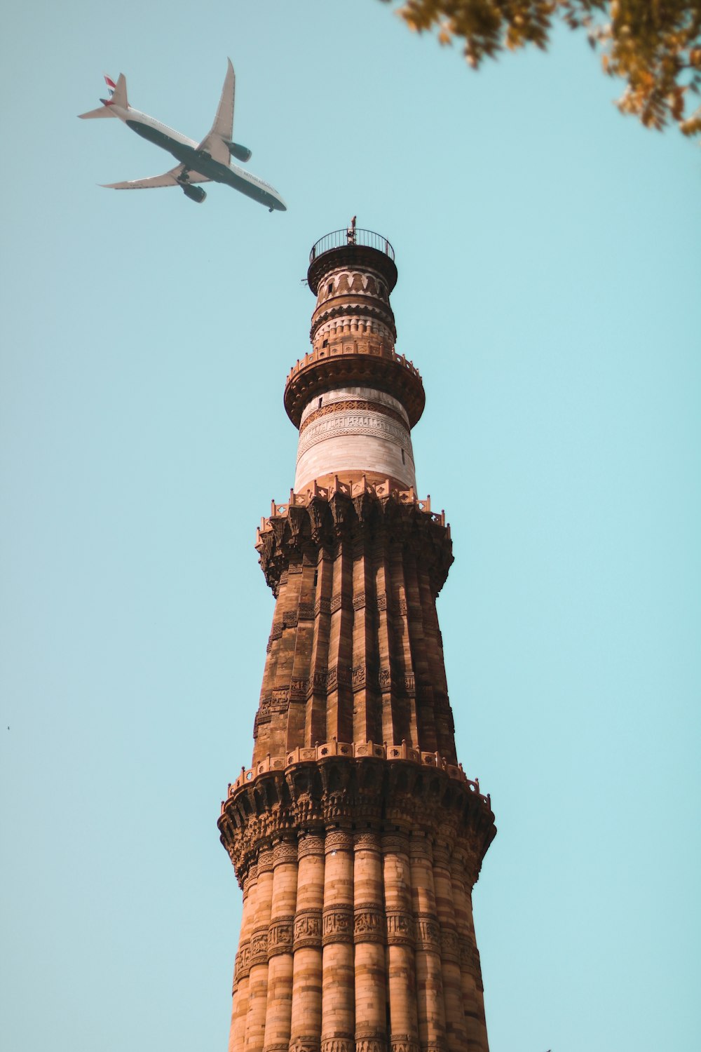 an airplane is flying over a tall tower