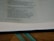 An open book displaying text with a focus on certain passages that discuss spiritual and moral themes. The page is light-colored with black printed text and a teal ribbon bookmark partially visible at the bottom. The book rests on a wooden surface.