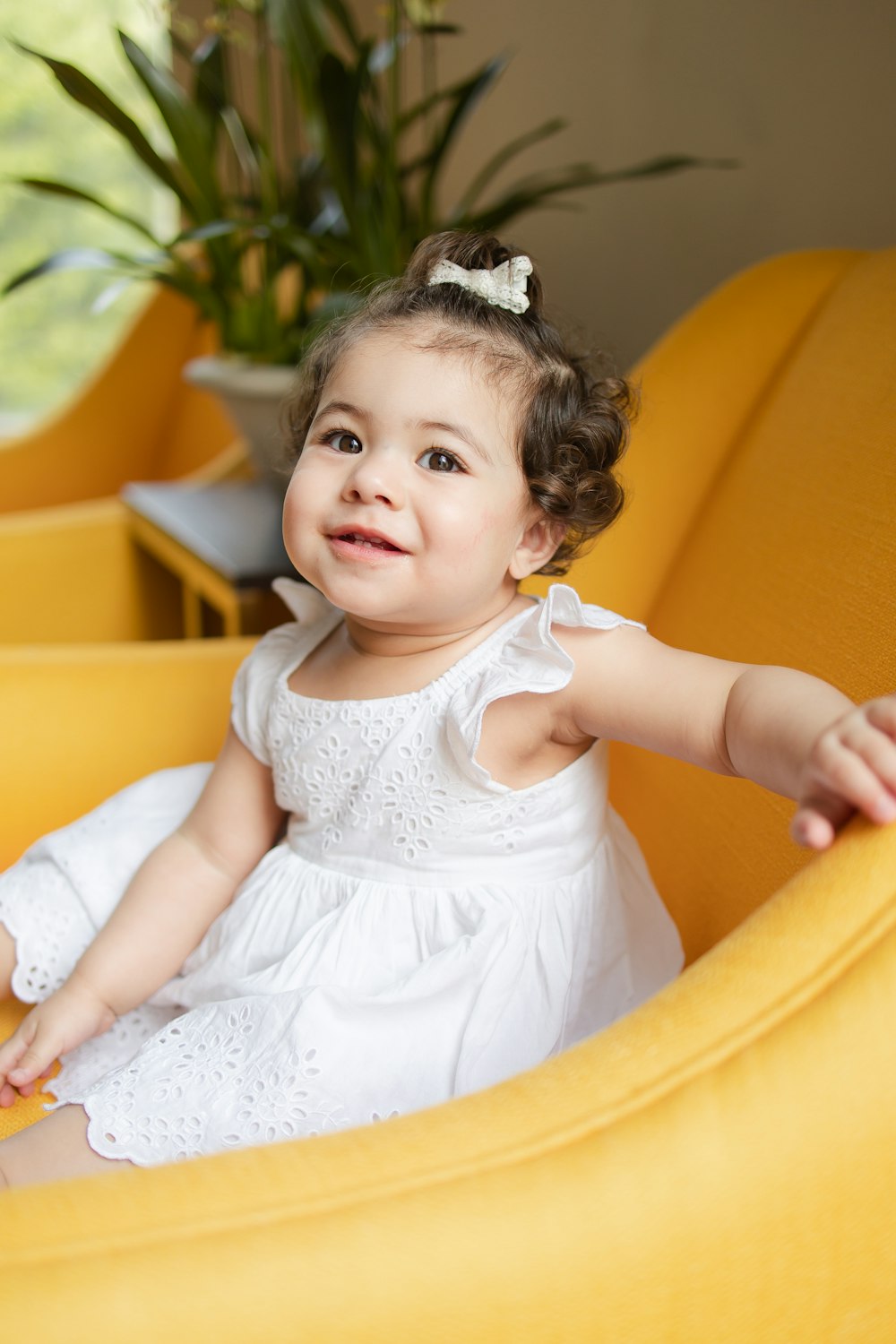 a little girl sitting in a yellow chair