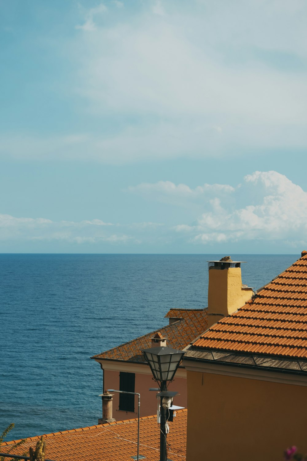 a view of the ocean from a rooftop of a house