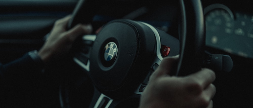 a person holding a steering wheel while driving a car
