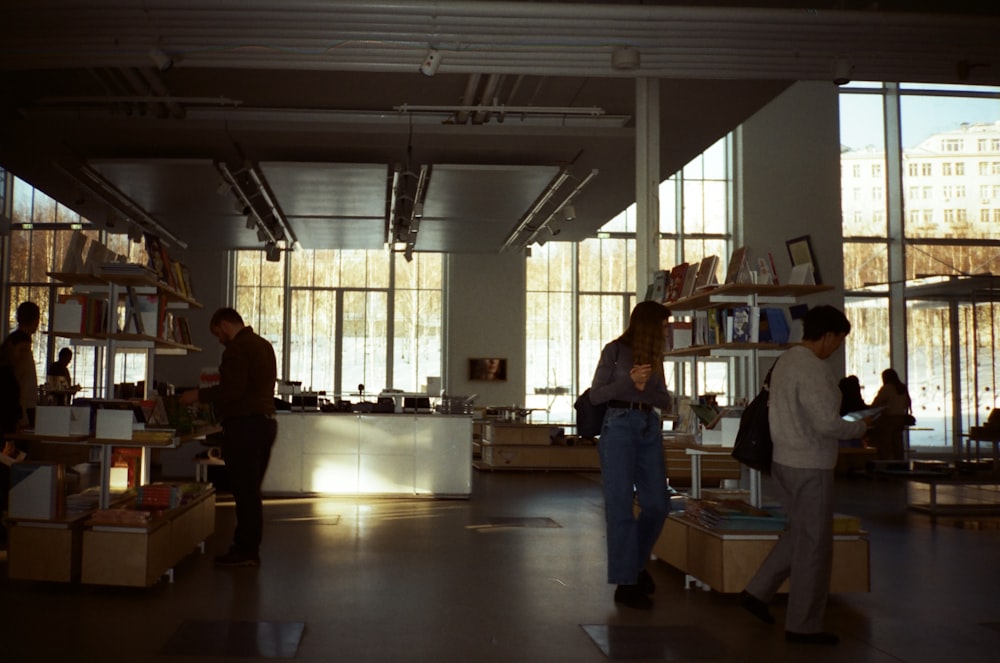 a group of people standing around a room filled with books