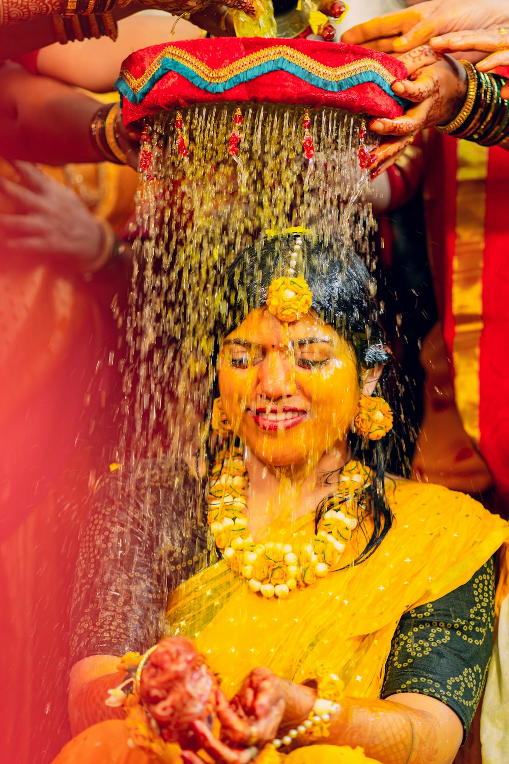 a woman is covered in yellow powder and water