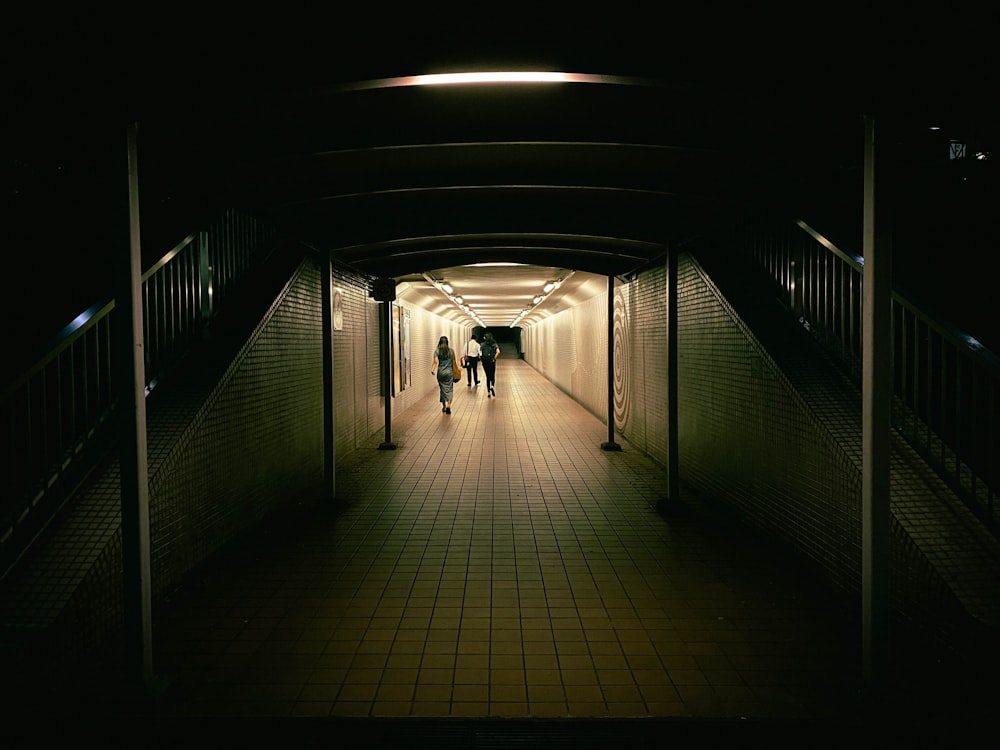 a couple of people walking down a long hallway