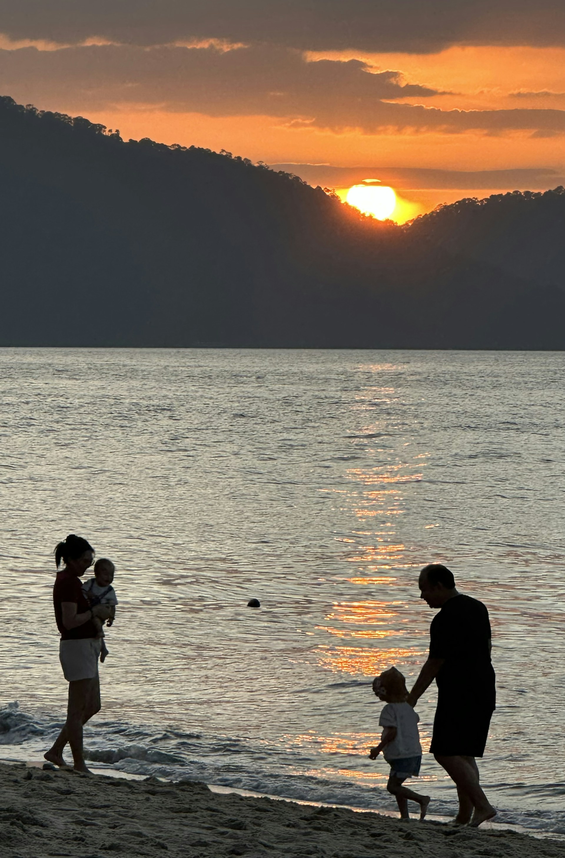 A serene family gathering on the beach at sunset, capturing joyful moments and warm smiles.