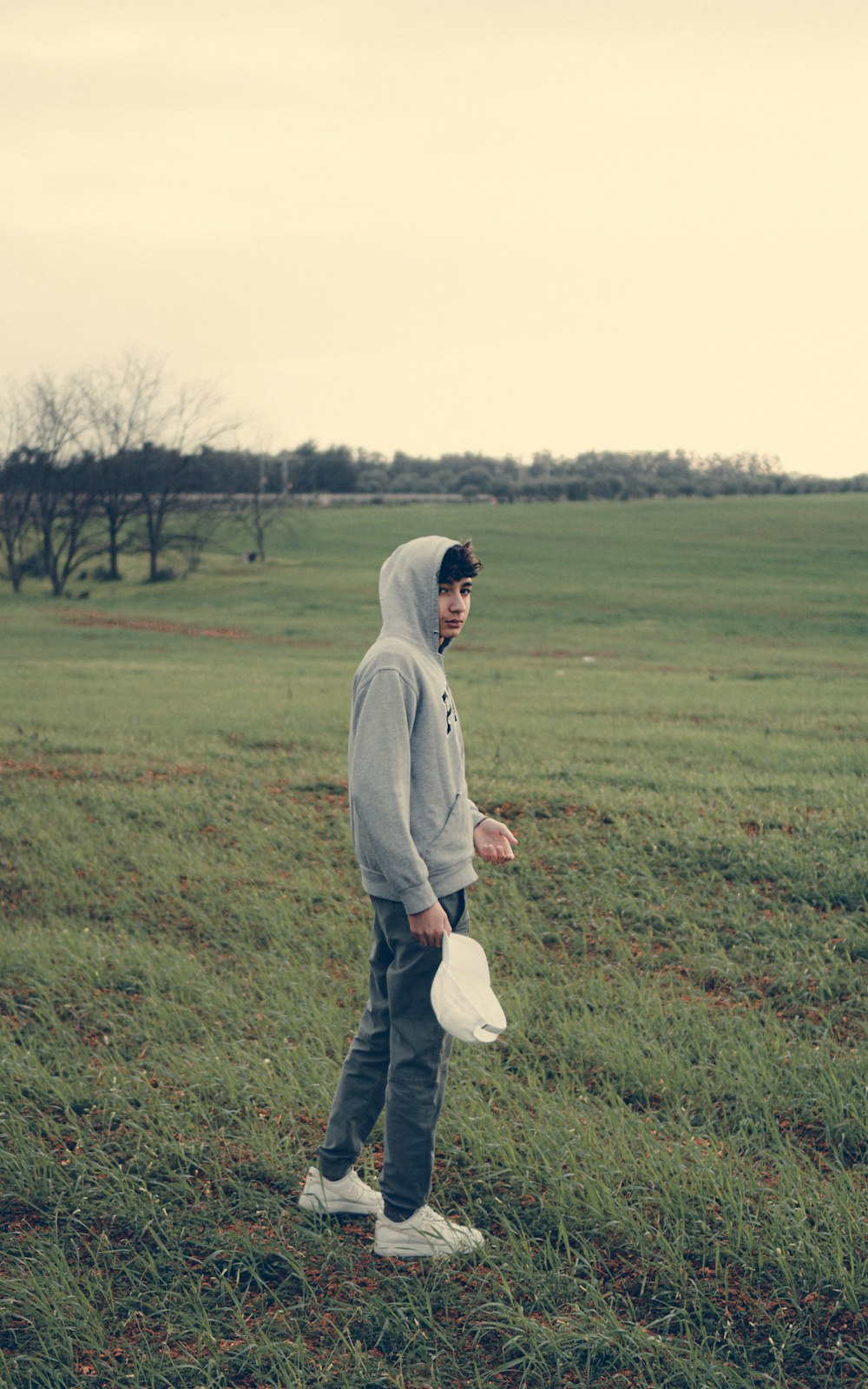 a man standing in a field with a frisbee