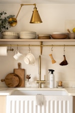 a kitchen with a white sink and gold faucet