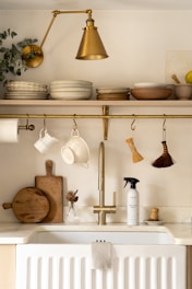 a kitchen with a white sink and gold faucet