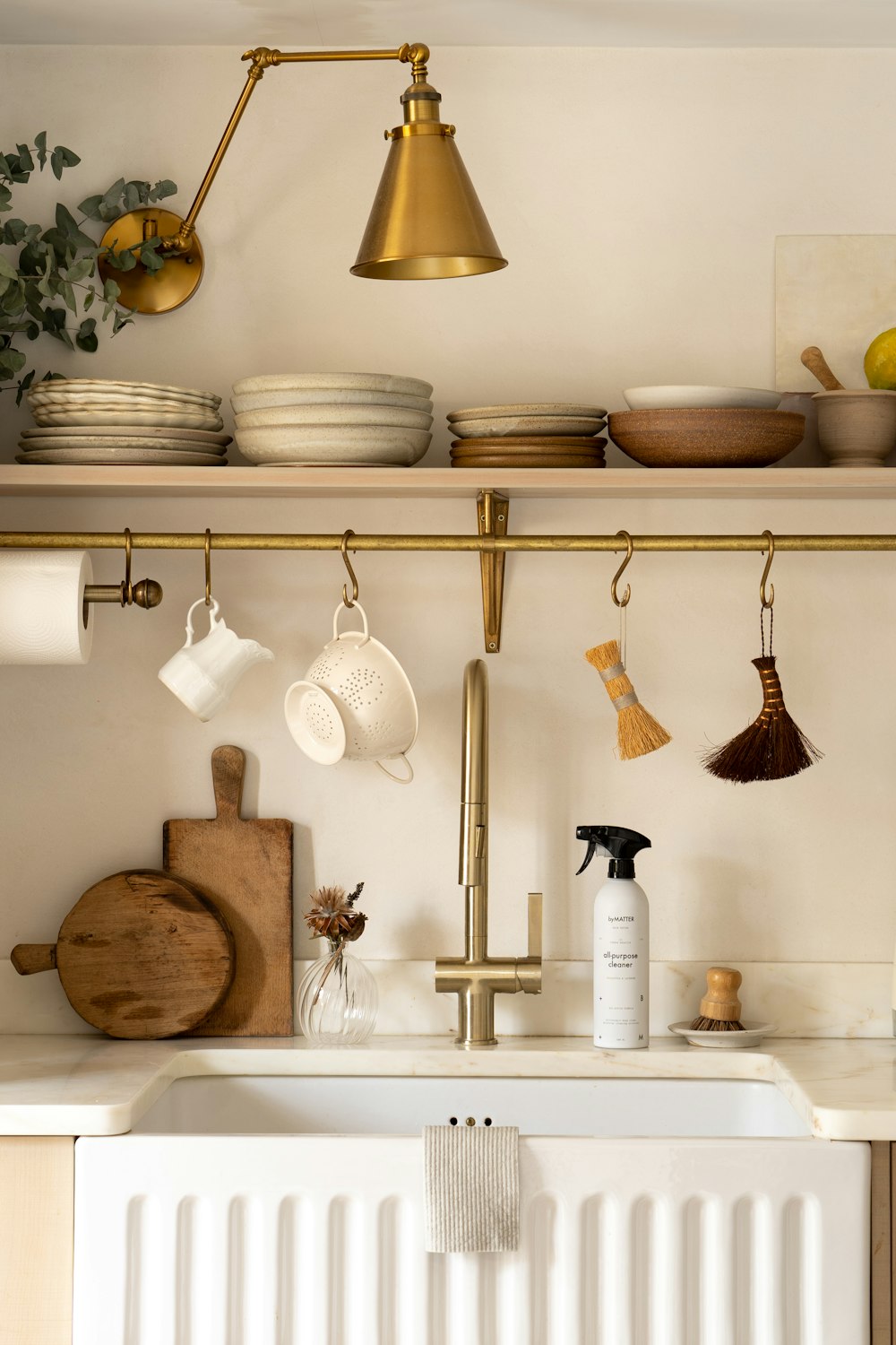 a kitchen with a white sink and gold faucet