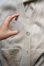 a person holding a bottle of perfume in their hand