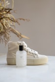 a bottle of cologne next to a pair of sneakers