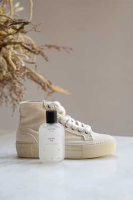a bottle of cologne next to a pair of sneakers