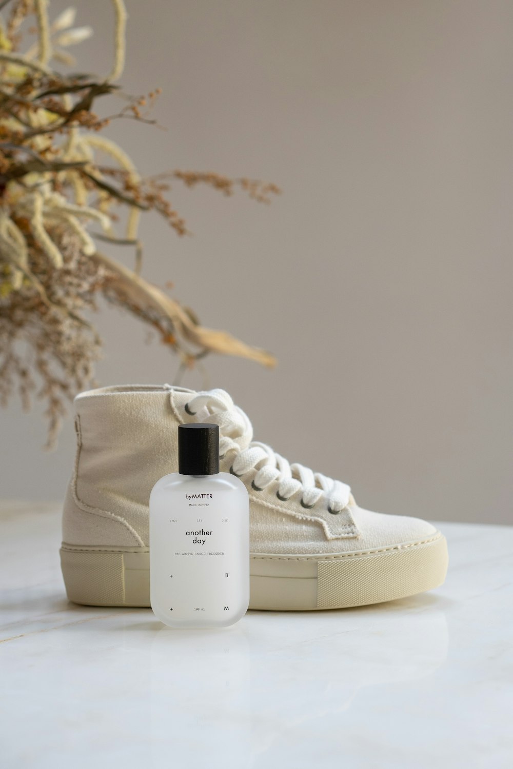 a bottle of cologne next to a pair of sneakers