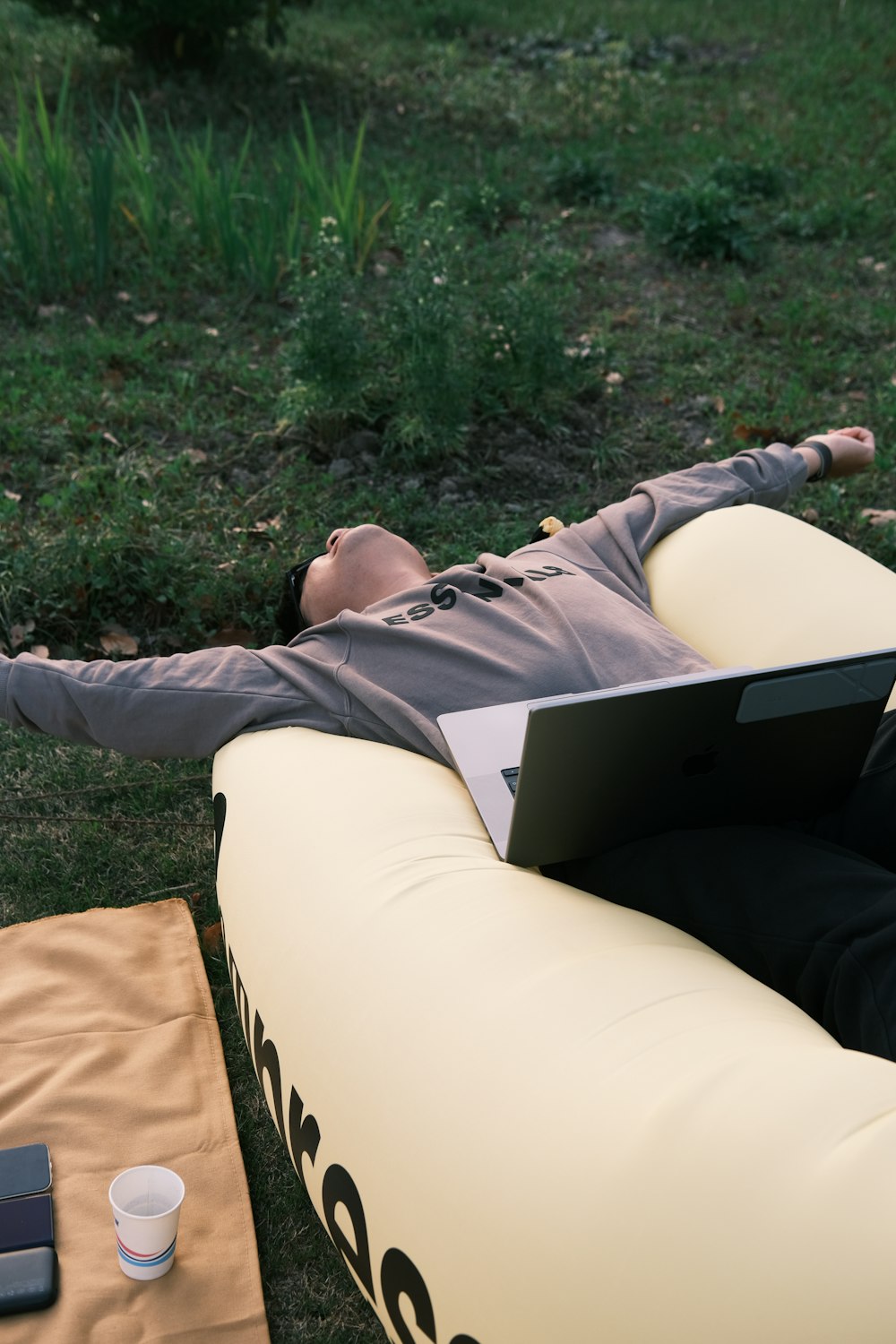 a man laying on a bean bag chair with a laptop