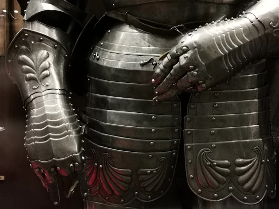 Close-up of a sleek spandex suit with intricate 3D-printed armor details glowing softly under crimson light.