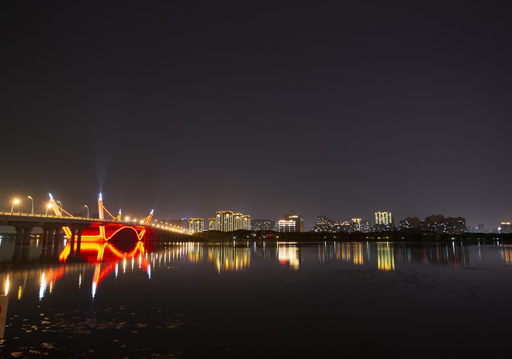 a bridge over a body of water with a city in the background