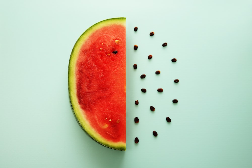 a slice of watermelon and seeds on a blue background