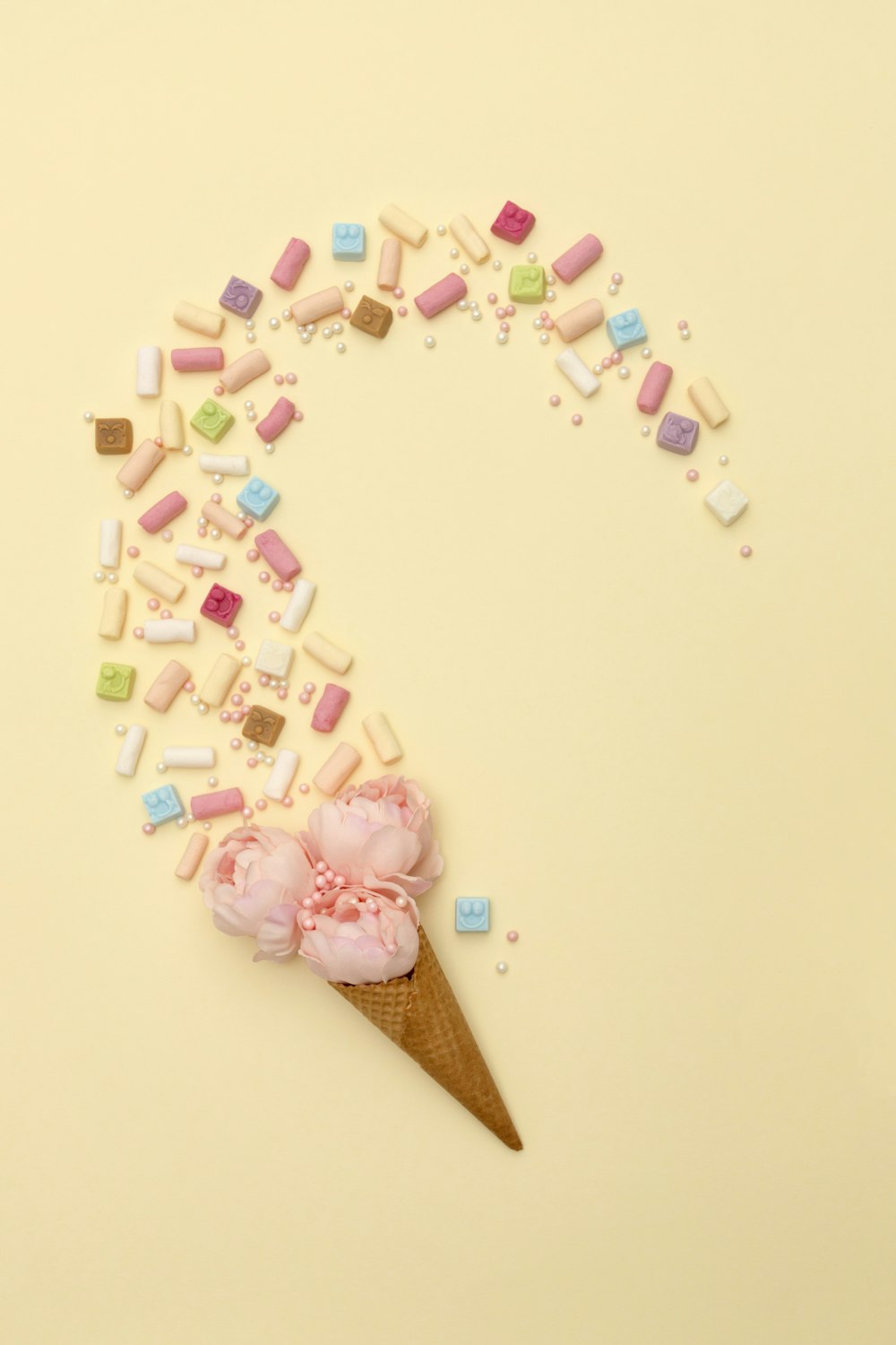 an ice cream cone with marshmallows and a flower