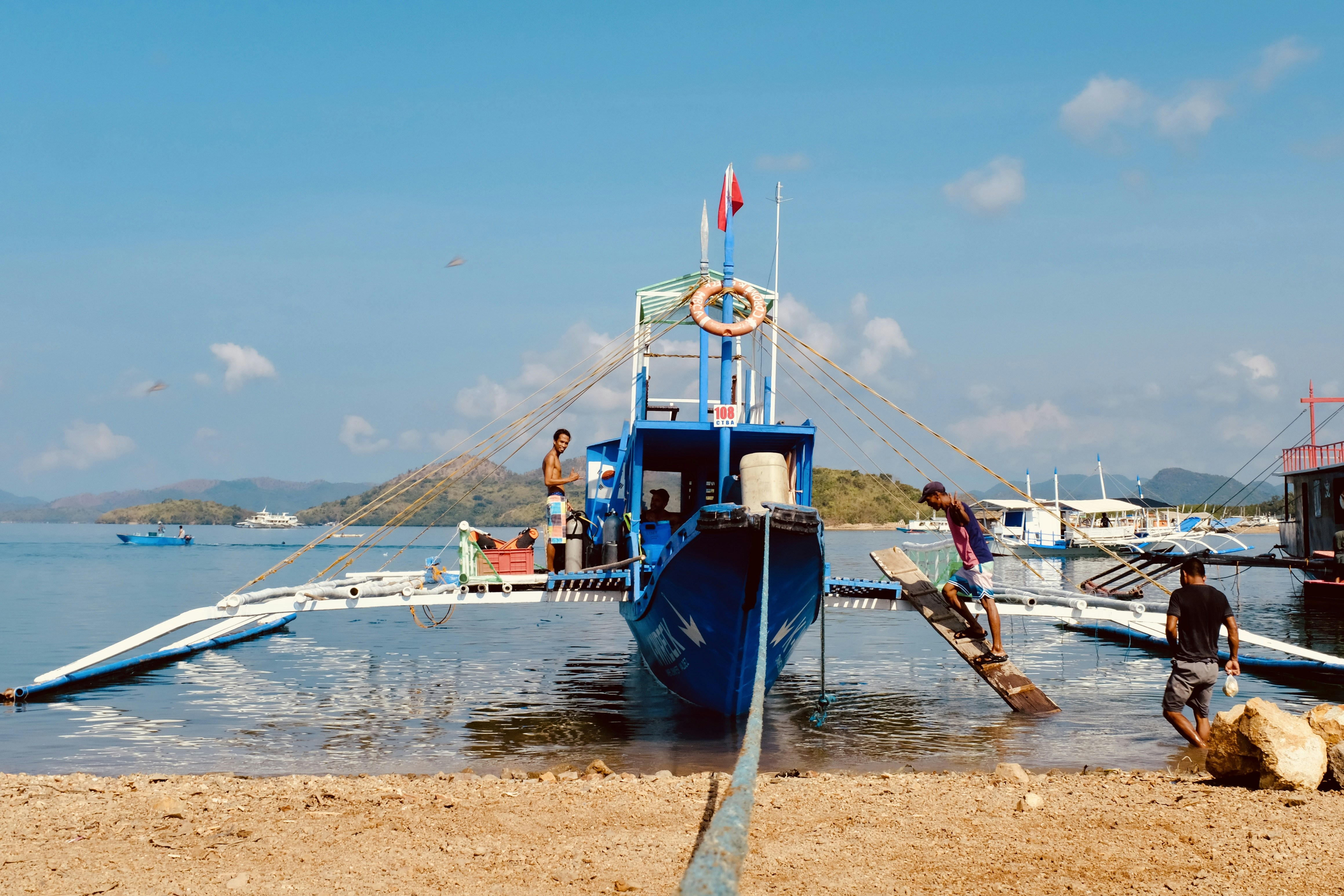 a blue and white boat sitting on top of a body of water