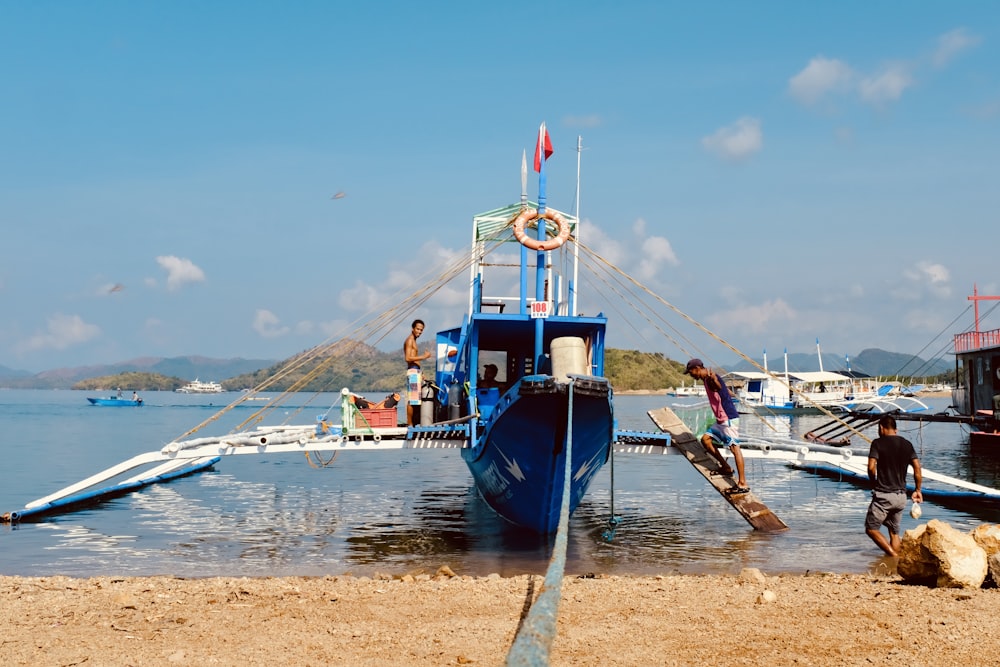 a blue and white boat sitting on top of a body of water