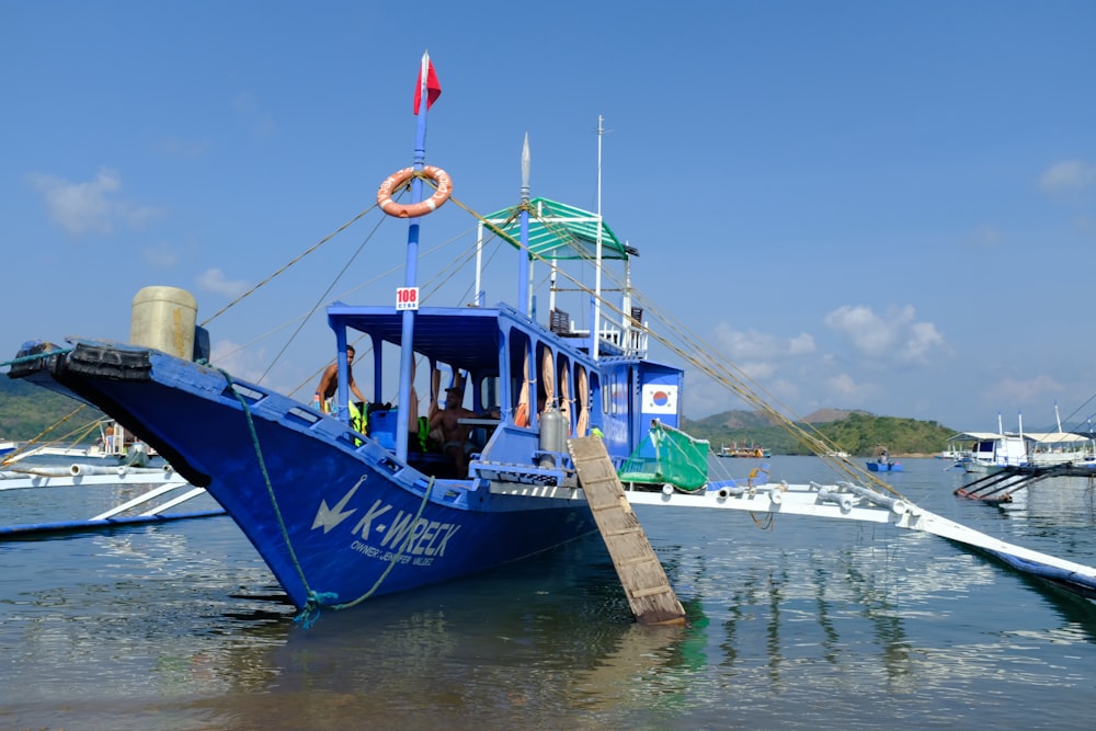 a blue boat sitting on top of a body of water