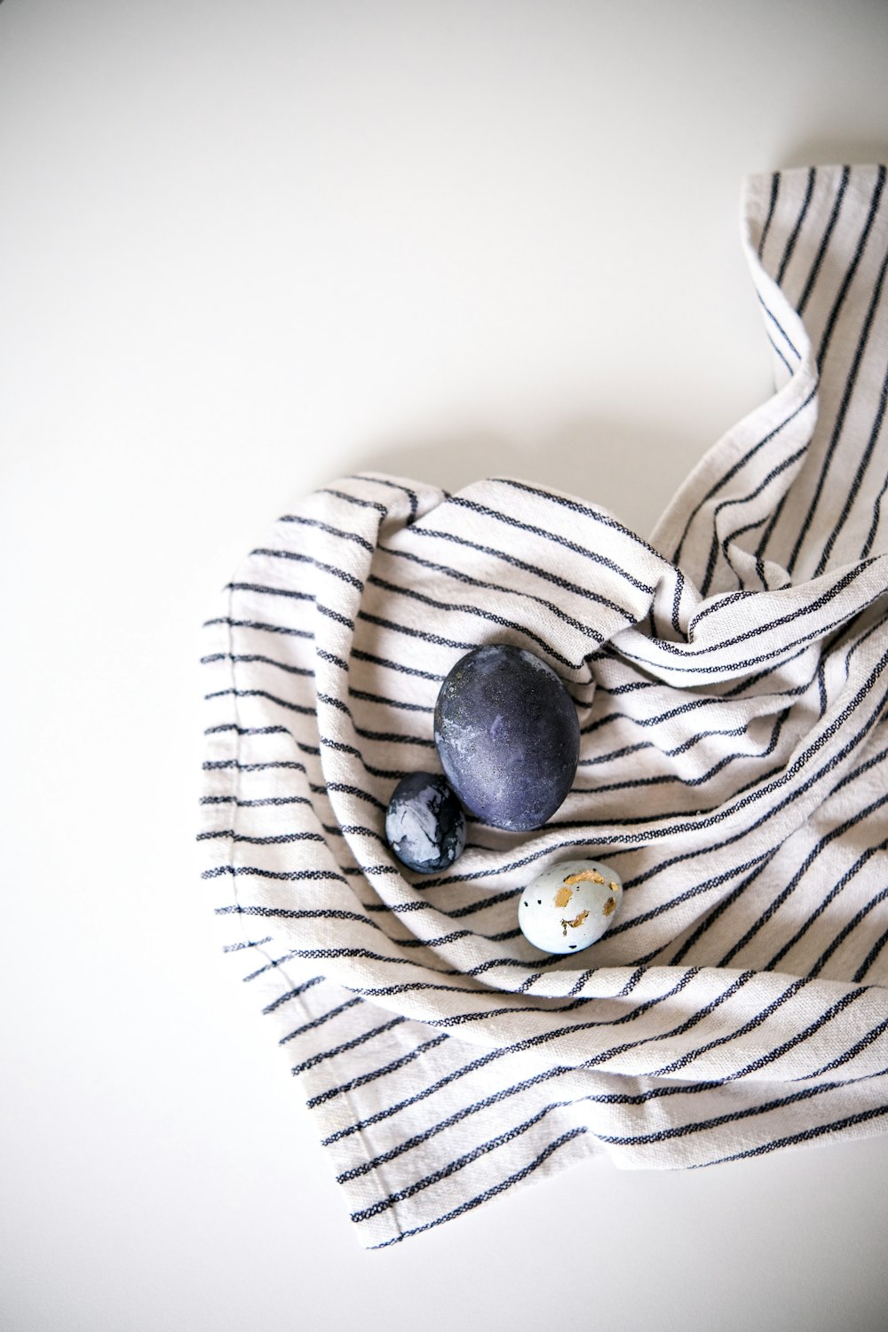 a striped scarf with two rocks on top of it