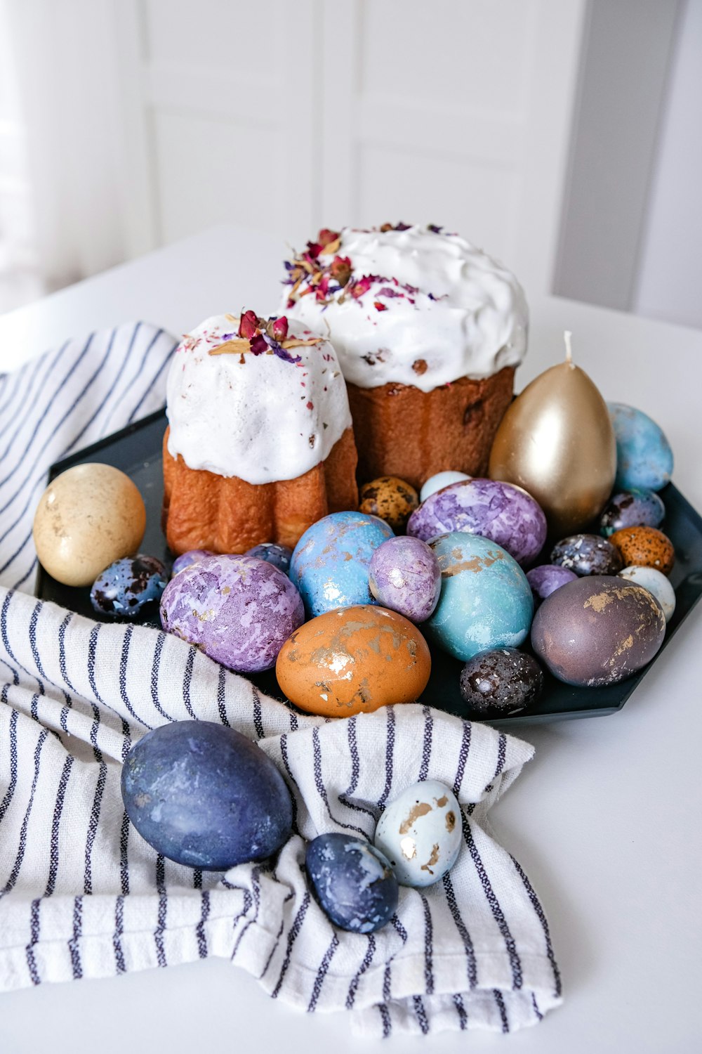 a plate topped with cakes covered in frosting and decorated eggs