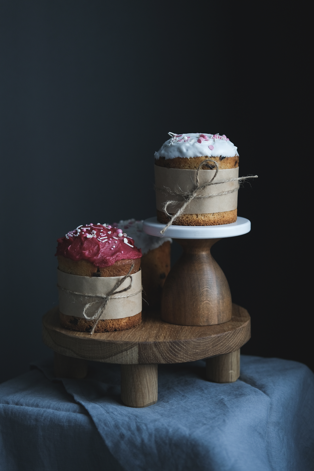 two cakes sitting on top of a wooden stand