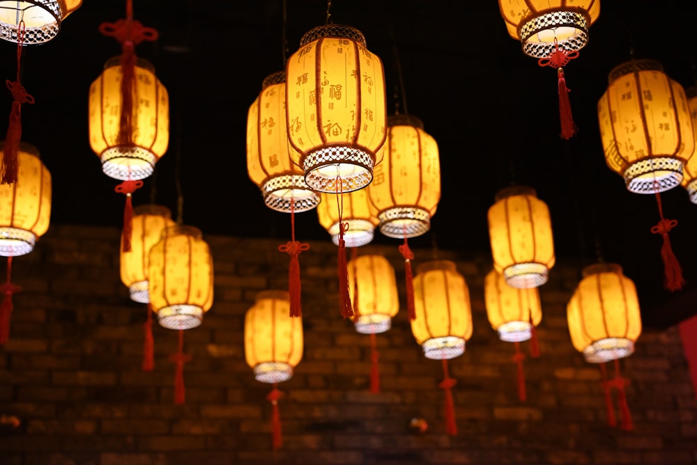 a bunch of yellow lanterns hanging from a ceiling